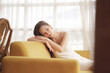 © THESHOTS.CO - Asian beauty woman resting on a couch in living room.