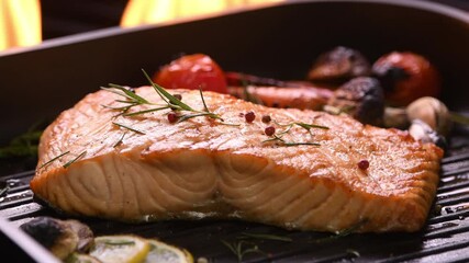 Wall Mural - Grilled salmon fish with various vegetables on pan on the flaming grill