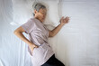 © Satjawat - Sad asian senior woman touching hip on her bed,problem of pain while sleep feel backache discomfort,female old elderly suffering from sudden back pain caused by uncomfortable mattress in the bedroom
