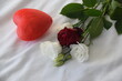Rose blanche et rouge  bouquet de rose  posé sur un lit avec son  cœur 