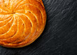 Epiphany cake or galette des rois in French on black slate background