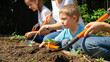 © Kyrylo Ryzhov - Happy family preparing garden soil for planting fresh organic vegetables sprouts on spring. Concept of teamwork and family having time together