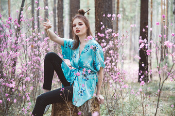 Poster - Japanese-style girl in a flowering forest among pink flowers in spring