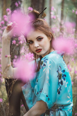 Wall Mural - Japanese-style girl in a flowering forest among pink flowers in spring