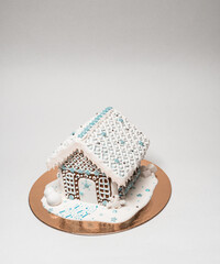 Close up isometric view shot of gingerbread house decorated with white glare and confetti isolated on white