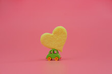 Small Toy Car Carrying Yellow Heart. Fun Love And Valentine's Day Celebration Concept