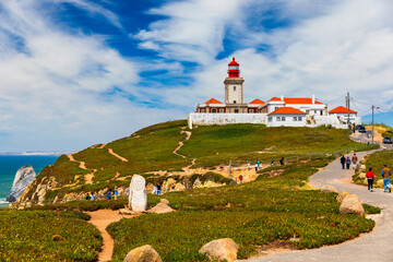 The lighthouse in Cabo da Roca. Cliffs and rocks on the Atlantic ocean coast in Sintra in a beautiful summer day, Portugal. Cabo da Roca, Portugal. Lighthouse and cliffs over Atlantic Ocean.