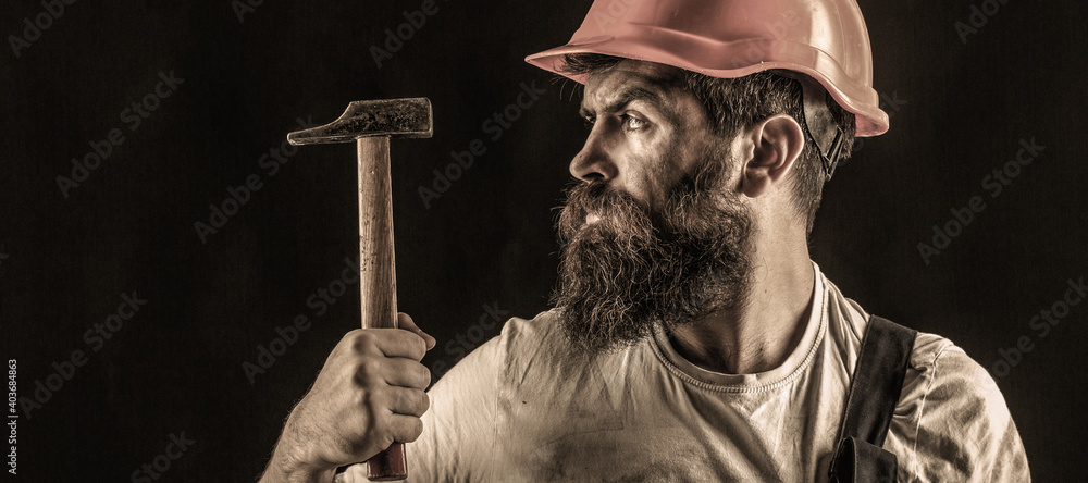 Handyman services. industry, technology, builder man, concept. Bearded man worker with beard, building helmet, hard hat. Hammer hammering. Builder in helmet, hammer, handyman - obrazy, fototapety, plakaty 
