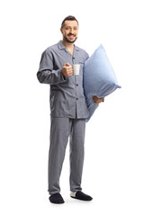 Sticker - Full length portrait of a man in pajamas holding a pillow and a cup