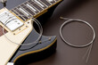 © Andrii - new music strings for electric guitar on a brown background. studio shot. space. restring concept. preparation to performance