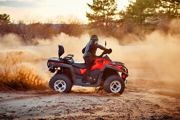 Wall Mural - Teen riding ATV in sand dunes making a turn in the sand