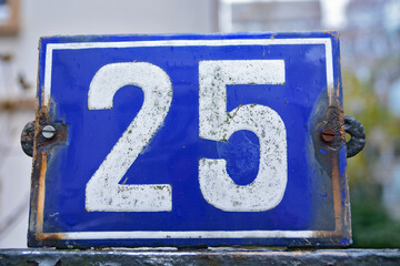 Wall Mural - A blue house number plaque, showing the number twenty five (25)