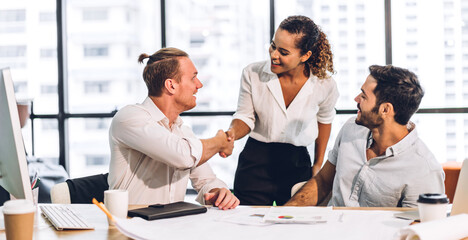 Wall Mural - Image two business partners successful handshake together in front of casual businessman in modern office.Partnership approval and thanks gesture concept