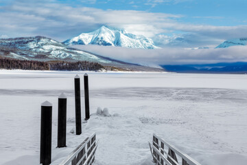 Wall Mural - Winter landscape of frozen Lake McDonald dock in Glacier National Park, Montana