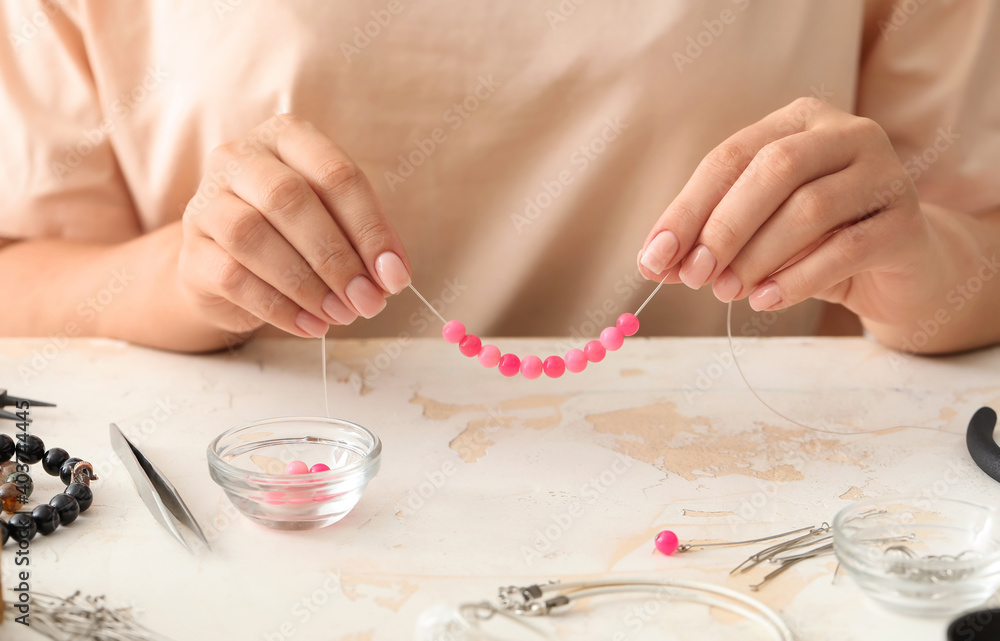 Female designer making jewelry at workplace