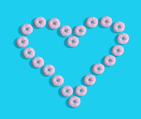 Wall Mural - Creative Valentines day concept with heart symbol made of pink donuts on pastel blue background. Flat lay design 