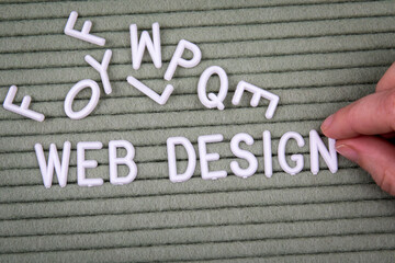 Wall Mural - web design. white letters of the alphabet with a woman's hand on a green background