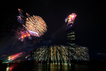 Colorful abstract fireworks next to the skyscraper architecture background to Happy New Year 2021