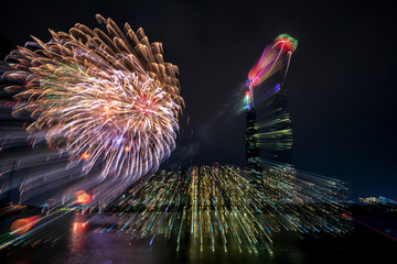 Colorful abstract fireworks next to the skyscraper architecture background to Happy New Year 2021