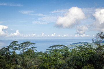 Poster - The landscape of the mountain ridge of Phuket and the Adaman Sea against the background of a blue sky with clouds.