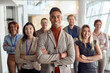 © luckybusiness - youjng afro-american businessman standing in front of his team. arms crossed, smiling, looking at camera.