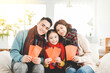© Tom Wang - happy chinese new year. asian family showing red envelope for lucky in living room
