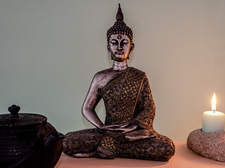 Poster - Statue of Buddha with candles on a table