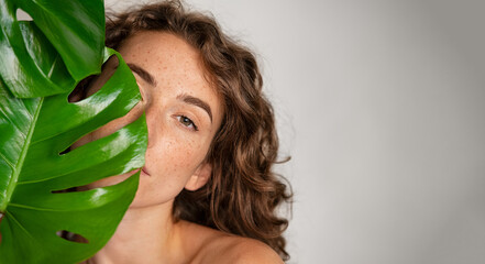 Wall Mural - beautiful woman with natural make up and green leaves