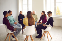 Psychological Support, Cooperation, Teamwotk, Unity, Togetherness Concept. Multiethnic Group Of People Of Different Age Sitting In Circle Discussing Problems Together Indoors In Light Spacious Office