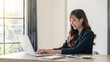 © ArLawKa - The smart, cute, charming, elegant businesswoman meets online with international business partners, she sits at a table at the workstation.