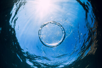 Ring bubble underwater and sun light in ocean. Water texture.