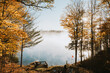 © Cavan Images - Foggy morning view of lake through the trees on an autumn day.