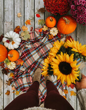 Overhead View Of Woman From Waist Down Holding Flowers With Fall Items