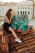 © Cavan Images - Female painter sitting on roof with abstract art canvas