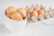 Raw Brown Fresh Chicken Eggs In China  Saucers And Container Made Of Recycled Paper On White Wooden Background Prepared For Easter. Healthy Eating And Sustainable Consumption Concept. Horizontal Image