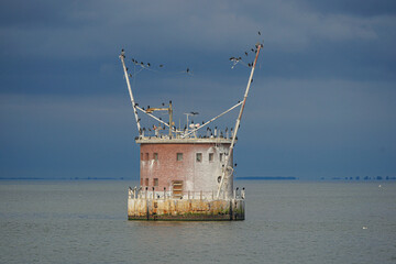 Poster - Round fortress in the open sea with many black birds flying around