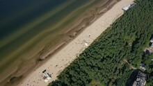 Jurmala, Dzintari, Latvia, Baltics. Beautiful Panoramic Aerial 4K Video From Flying Drone To Dzintari Sandy Beach Full Of People Sunbathing And Swimming In The Baltic Sea On A Hot And Sunny Summer Day