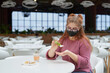 © pridannikov - White caucasian woman wearing face mask using sanitizer in a restaurant