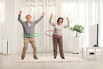 Elderly couple spinning hula hoops