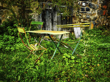 Vintage Old Metal Garden Furniture Surrounded By Lush Summer Foliage