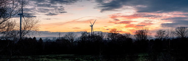 View of wind turbines during golden hour sunset in south wales uk pen y fan pond. energy concept.