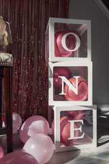 Sticker - Vertical shot of transparent containers with balloons stack on each other forming the word one