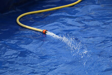 Closeup Shot Of A Hose Filling The Inflatable Pool