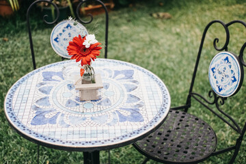 Blue mosaic table with flowers in garden