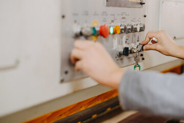 Canvas Print - Closeup shot of hands working the buttons of an industrial machine