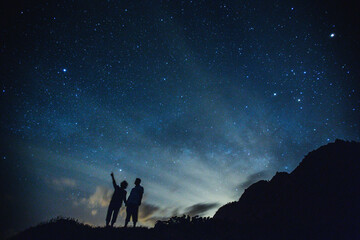 silhouette of elderly couple on the hill. stargazing at oahu island, hawaii. starry night sky, milky