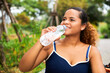 © JuYochi - American black woman traveler sit and relax and drink water.