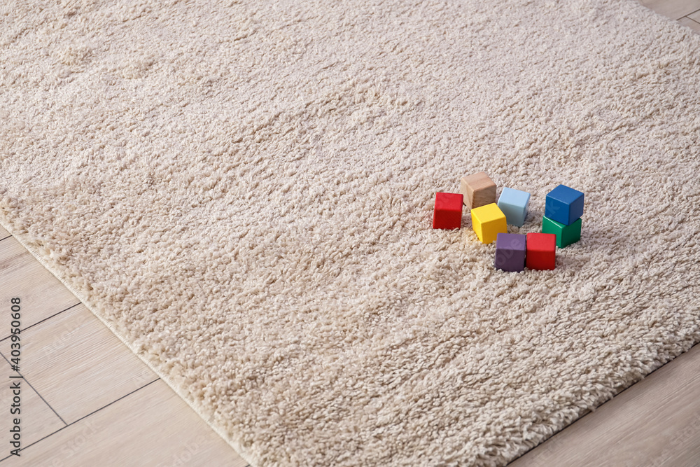 Cubes on soft carpet in room, closeup