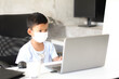 © Smile Studio AP - Asian boy kid sitting at table with laptop and preparing to school. Online education concept. Online video call conference class lesson study.