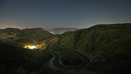 Wall Mural - night time lapse of a road winding through the mountains.